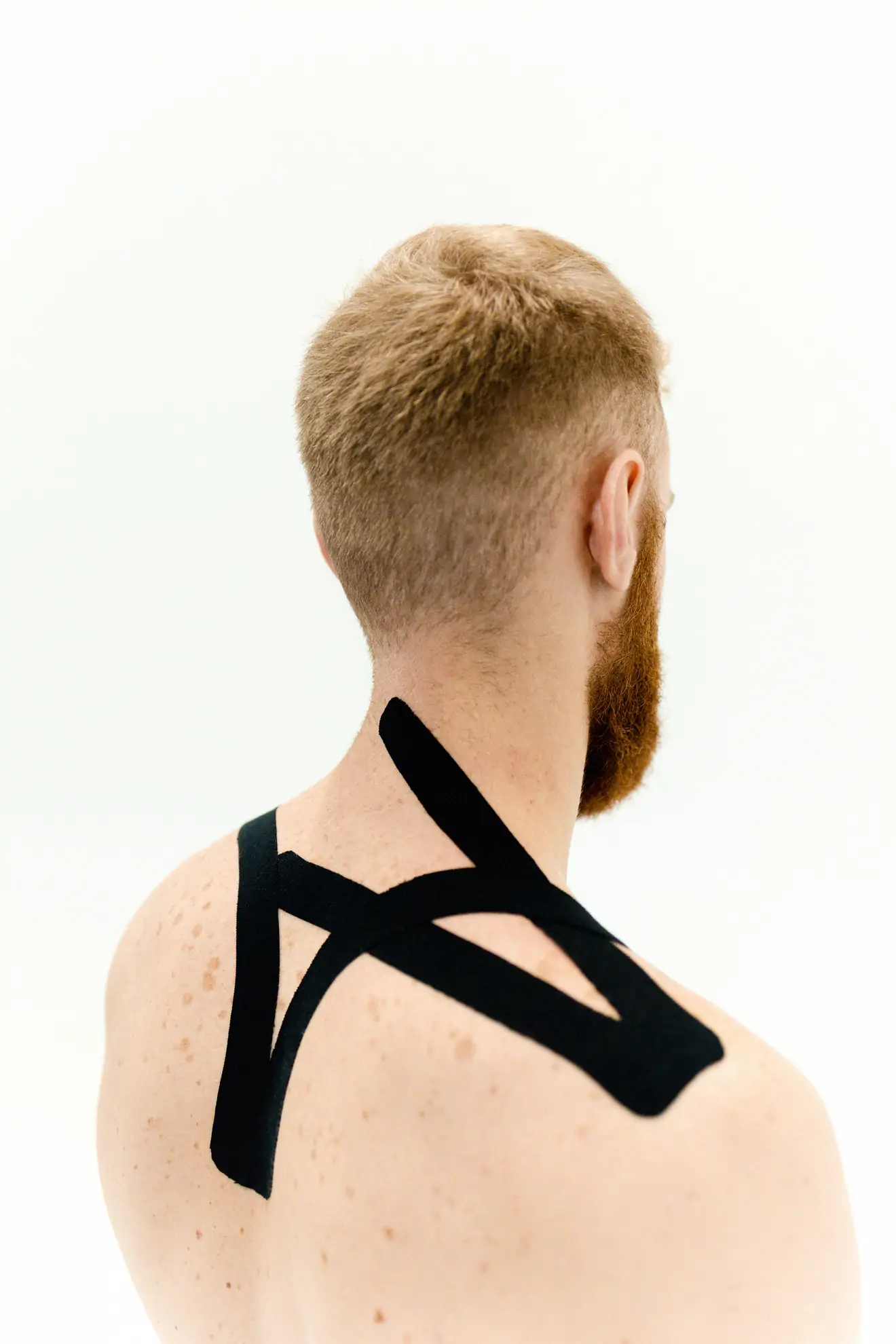Kinesio-Tape in verschiedenen Farben auf der Schulter einer Patientin